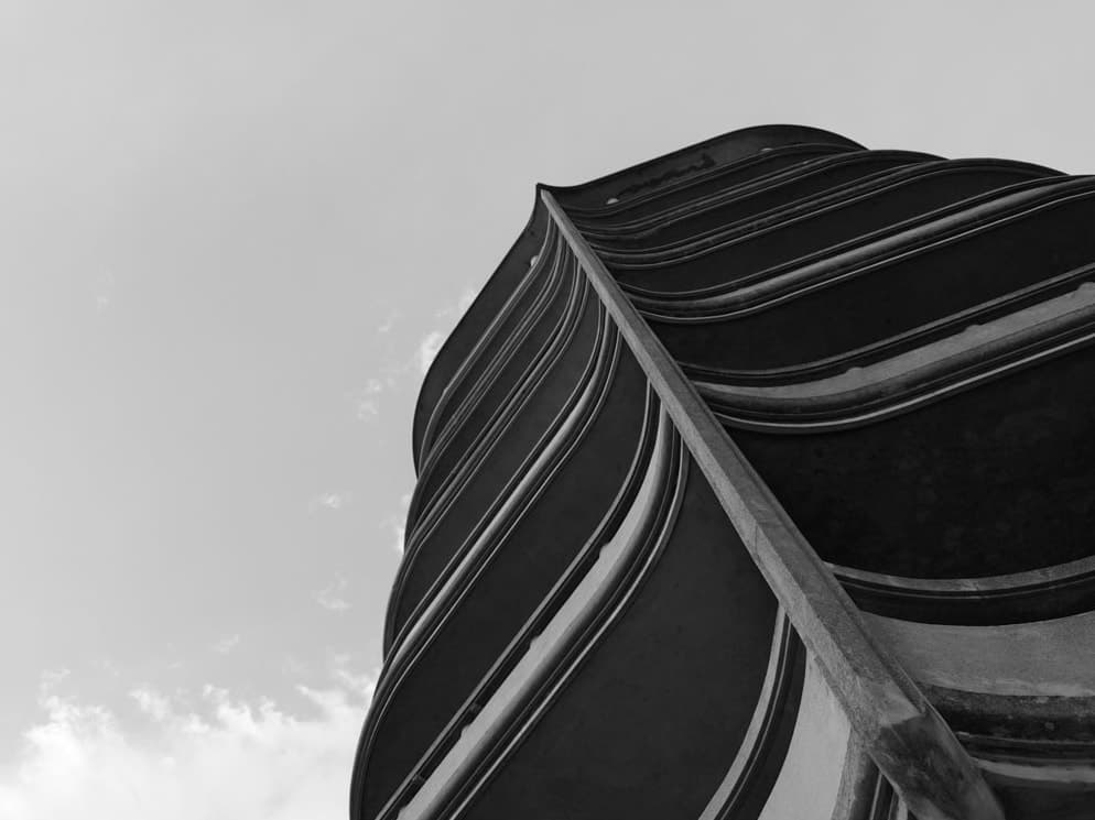 The curving balconies of a modernist tower seen from below