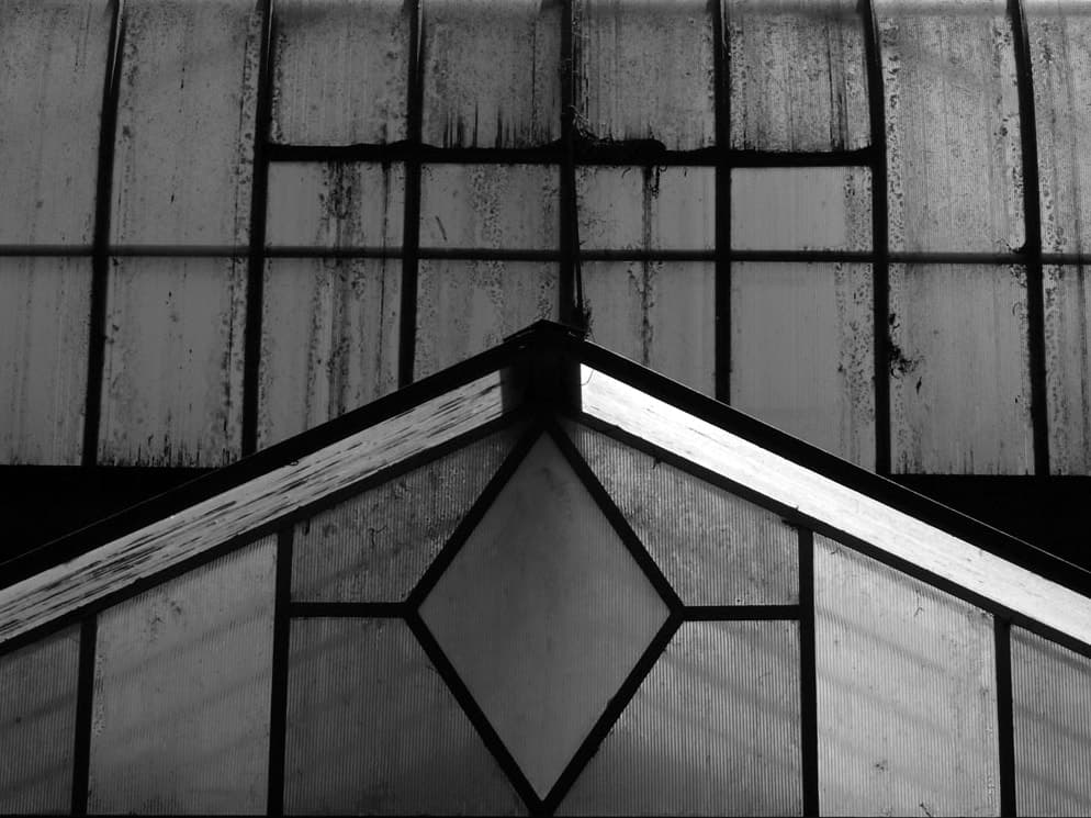 Geometric panes and the pitched roof of an old glasshouse
