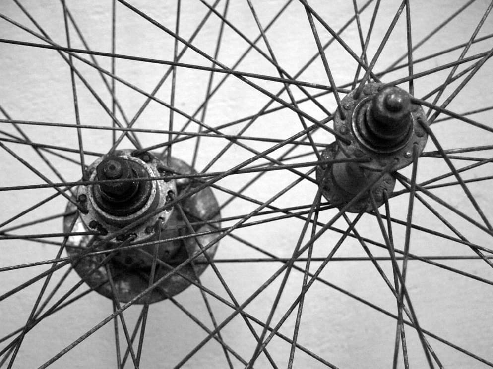 The overlapping spokes and hubs of two bicycle wheels